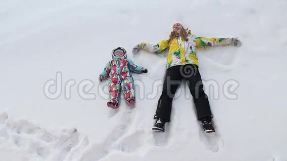 一对母亲和婴儿正在雪地上做天使视频的预览图