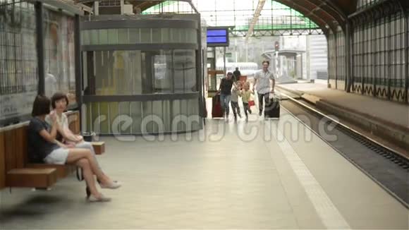年轻的一家人有两个配偶一个儿子另一个女儿在火车离开火车站之前跑步去赶火车视频的预览图