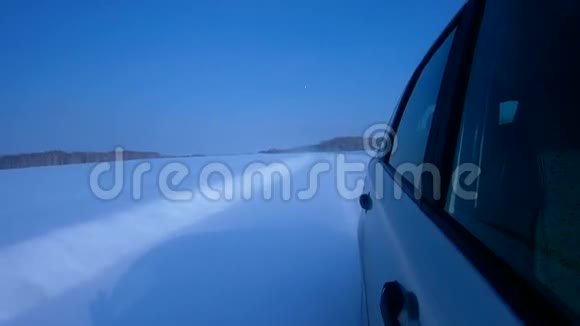 在寒冷晴朗的日子里汽车在冬天的路上行驶视频的预览图