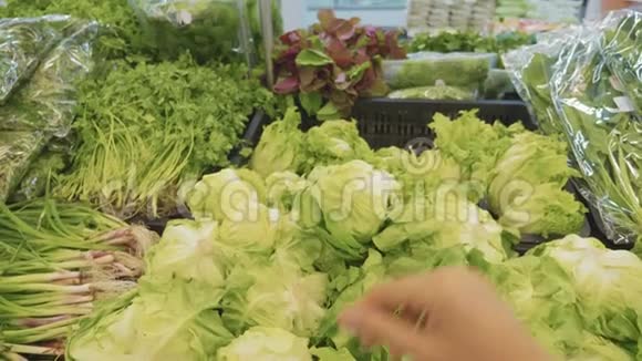 在杂货店挑选绿色蔬菜的年轻女子视频的预览图