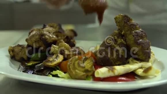 厨房餐厅做饭厨师用蔬菜酱装饰烤肉视频的预览图