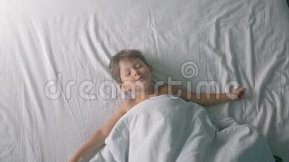 小男孩醒来后躺在床上视频的预览图