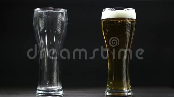 啤酒倒在黑色背景上的空杯子里视频的预览图