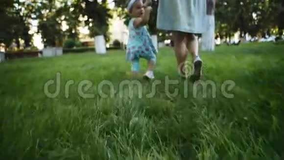 母亲和孩子在草地上散步视频的预览图