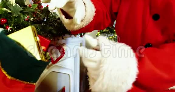 圣诞老人在壁炉上放置礼品盒的中间部分视频的预览图