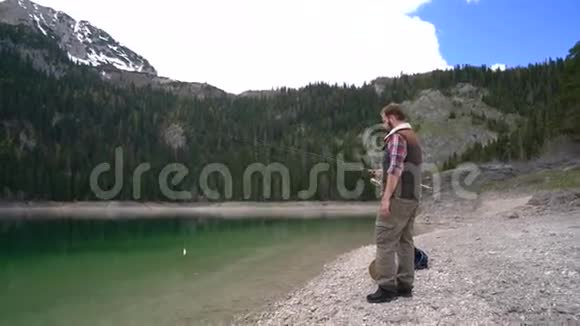 年轻人在风景优美的湖岸上旋转视频的预览图