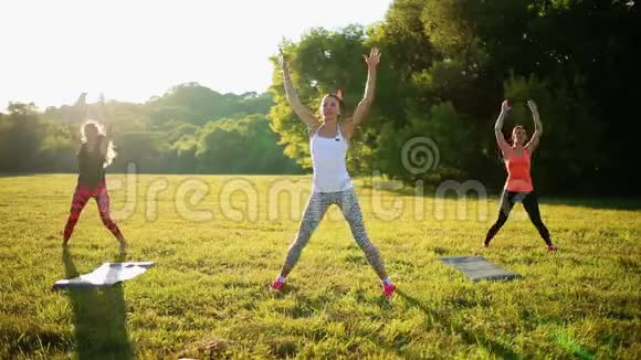 漂亮的女运动员在公园里用哑铃做运动视频的预览图
