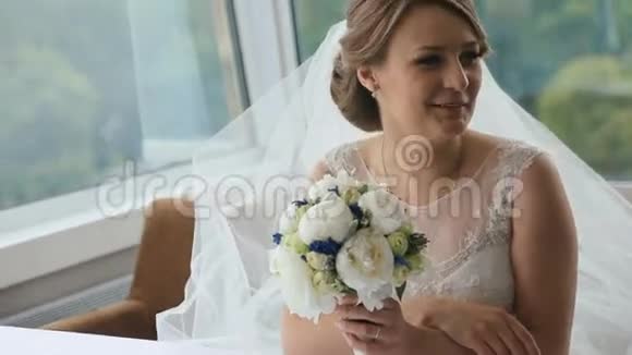 快乐的金发新娘一束结婚花坐在餐桌旁的咖啡馆里视频的预览图