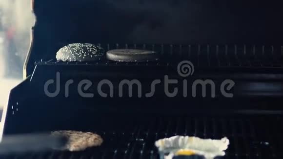 在餐厅厨房的烤架上为黑汉堡准备鸡蛋和切肉视频的预览图