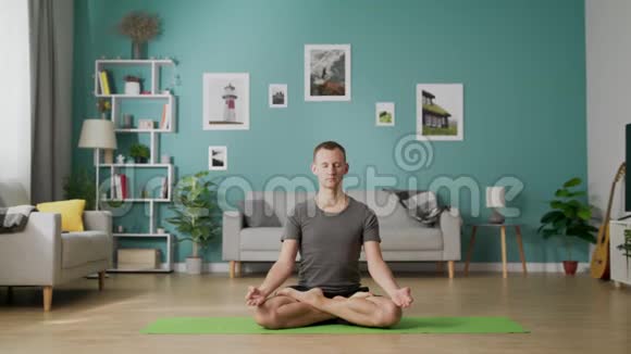 男人早上在家里客厅做瑜伽视频的预览图