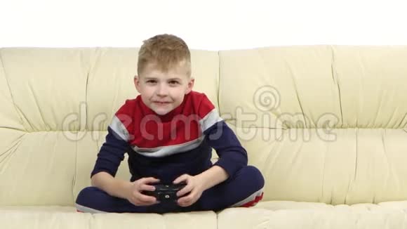有游戏机的男孩在沙发上玩电子游戏视频的预览图