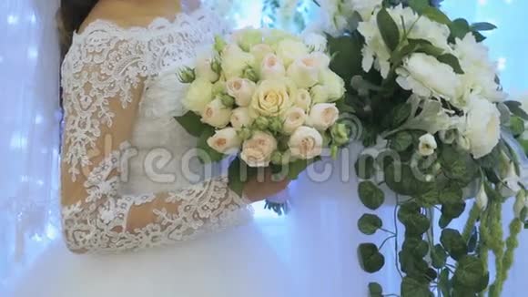 新娘站在室内的花拱旁边视频的预览图