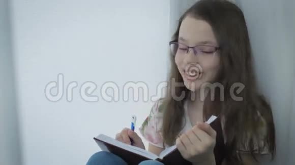 情绪激动的戴着眼镜的小女孩在日记里写着笑视频的预览图