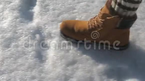 人们脚上的棕色冬鞋在白天穿过雪地视频的预览图
