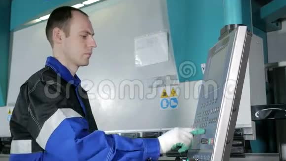 工程师在工厂控制液压折弯机数控人仔细输入制造零件的数据视频的预览图