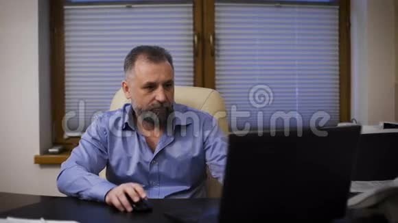 有经验的经理老板尊敬的比泽曼在他的办公室里用笔记本电脑工作视频的预览图