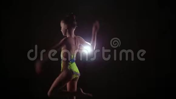 漂亮可爱的小女孩运动员穿着鲜艳的泳装表演艺术体操元素视频的预览图