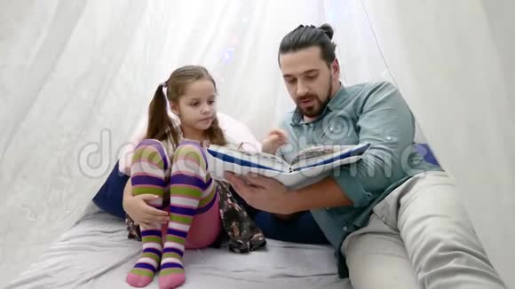 小女孩和她父亲一起读一本书视频的预览图