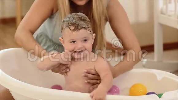 妈妈在房间的浴室里给婴儿洗澡视频的预览图