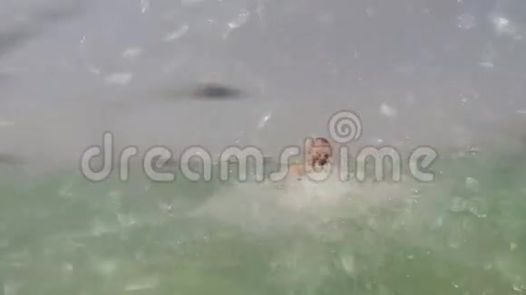 这个男孩沐浴在大海里洒满了水慢速射击视频的预览图