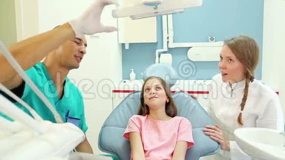 男牙科医生检查可爱的牙痛小病人视频的预览图