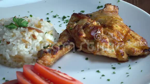 头在烤鸡腿上滴加叉的辣黄油有鸡肉米饭和西红柿的盘子视频的预览图