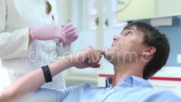 把微笑的男性病人送到牙医那里视频的预览图
