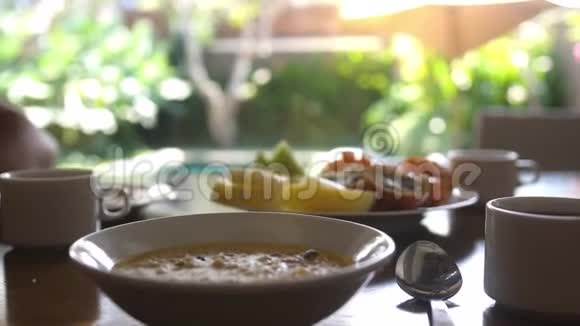 度假期间提供健康美味的早餐包括热带水果和燕麦粥和一杯咖啡视频的预览图