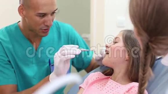 牙科助理和小女孩做牙齿检查后的高五视频的预览图