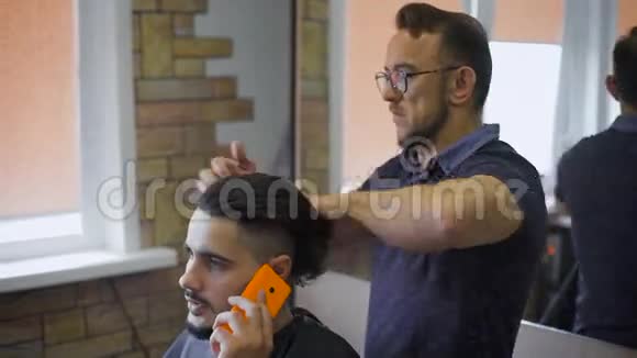 时髦的发型师时尚的理发师为年轻的嬉皮士完成了一项工作视频的预览图