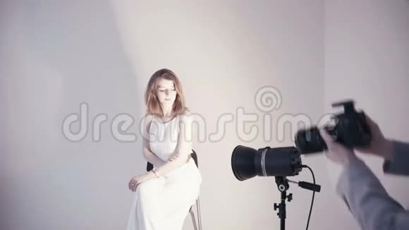 年轻的欧洲妇女穿着白色连衣裙在摄影棚拍照视频的预览图