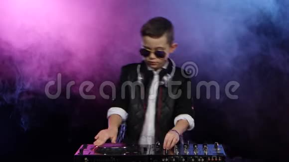 时尚男孩DJ与眼镜玩乙烯基吸烟背景视频的预览图