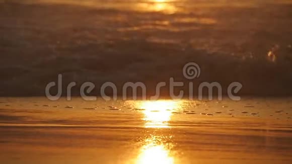 日落时美丽的金色海浪橙色的日出反射在海水上波浪在大风上溅起的浪潮视频的预览图