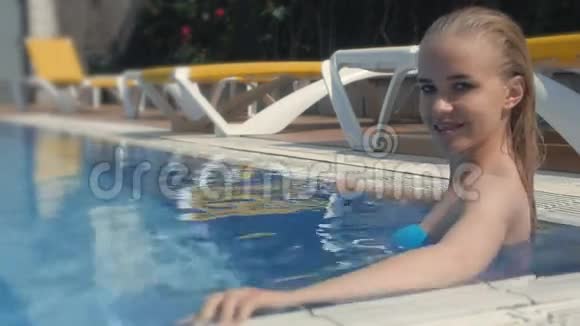 泳池里湿漉漉的年轻美女金发美女的肖像视频的预览图