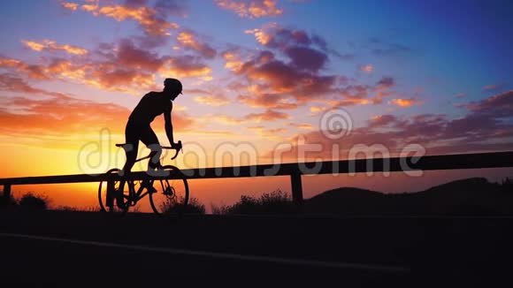 山上日落时骑自行车的人的剪影视频的预览图