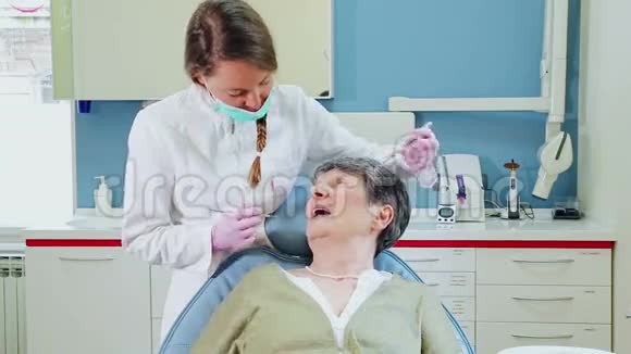 为年老病人做牙科治疗的女牙医视频的预览图