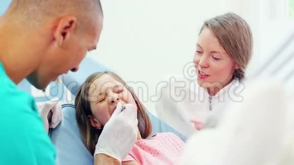 小女孩和牙科助理做了牙齿检查后的击掌视频的预览图