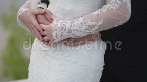 新娘手里拿着结婚花束新郎从后面拥抱她新郎从背后拥抱新娘视频的预览图
