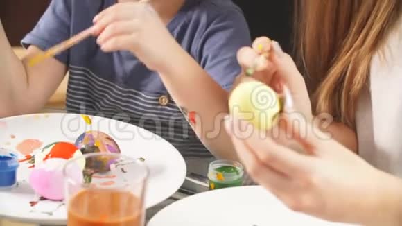 女人用小儿子装饰复活节彩蛋视频的预览图