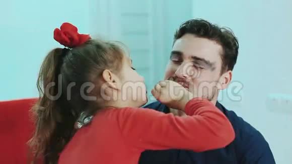 有趣的家庭父亲和他的女儿女儿向她父亲画嘴唇视频的预览图
