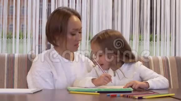 一位美丽的年轻女子画着她可爱的小女儿视频的预览图