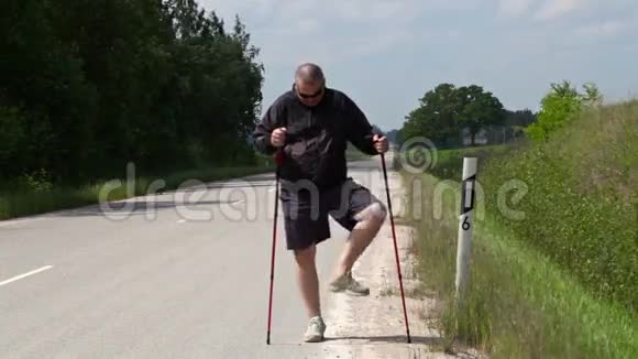 徒步旅行者用手杖在公路上做运动视频的预览图