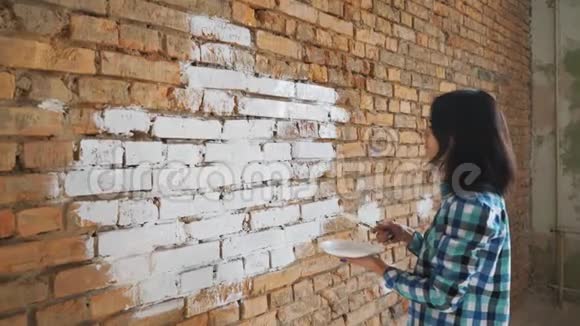 女人在房子里画一块白色的红砖视频的预览图