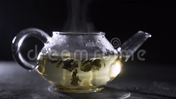 绿茶是用玻璃茶壶在黑色背景下酿造的视频的预览图