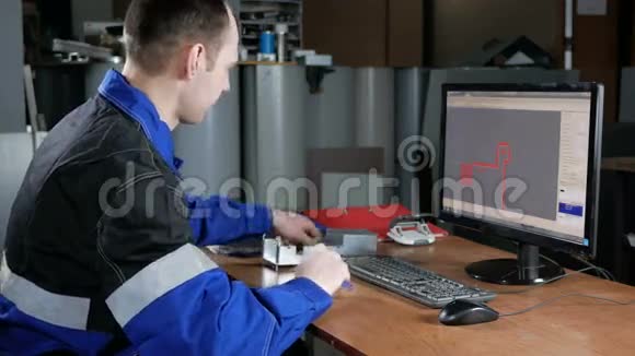 男工程师测量项目并将数据输入计算机程序数控机床工作服卡钳在他身上视频的预览图