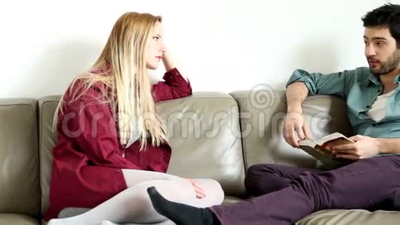 坐在舒适沙发上和帅哥说话的女人视频的预览图