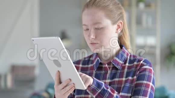 年轻女子网上购物使用平板电脑视频的预览图
