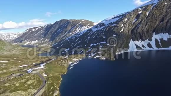 空中无人机在挪威湖旁的山路观景视频的预览图