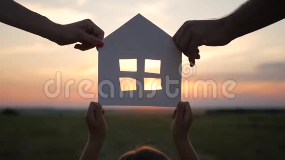剪影把一家人和纸房放在天空日落的背景下视频的预览图