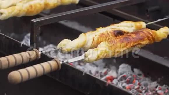 在烤架上的烤串上旋转的奶酪糕点视频的预览图